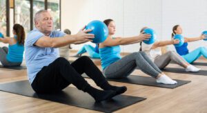 PIlates Training mit dem Ball auf der Matte, durchgeführt von jungen Menschen und vom Opa; gute Ergänzung zur ganzheitlichen Heilmassage - PIlates für alle!